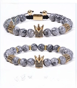 Detail of 8mm map stone beaded bracelets featuring a gold crown with black crystals