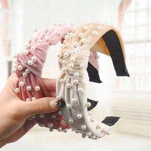 Detail of pink and beige velvet headbands with knot design and inlaid white pearls