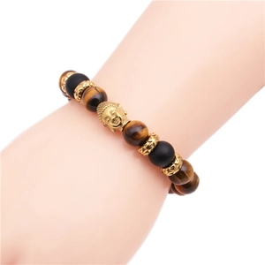 Dettaglio della perla testa di Buddha su bracciale intrecciato in occhio di tigre