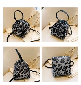 Detail view of leopard print triangle bag showing handle, strap and zipper closure