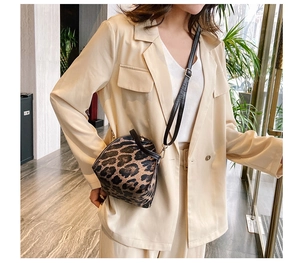Fashionable leopard print mini crossbody bag shown worn with a beige blazer outfit
