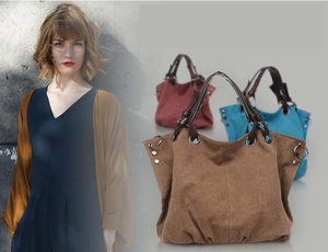 Detailed view of large canvas tote bag featuring PU leather handles in brown, red, and blue