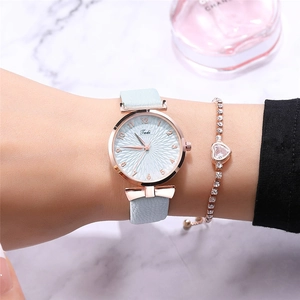 Detail of light blue slim leather strap watch and crystal heart bracelet on a wrist