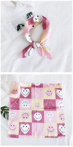 Detail of colorful geometric printed silk scarf with smiley face and heart patterns