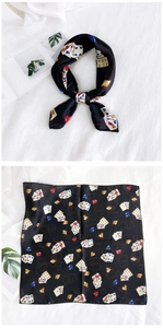 Detailed flat lay of black square silk scarf with vintage poker card print patterns