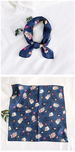Detail of navy blue satin neck scarf featuring creative poker card print and rolled edges