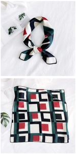 Detail view of square silk scarf with red, green, and black geometric patterns