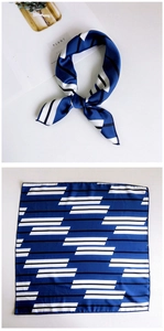 Detail of square silk scarf with navy blue geometric patterns and machine-stitched edges