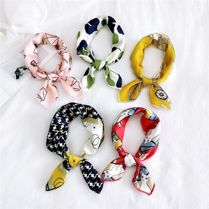 Flat lay of multiple stylish printed square scarves with floral and abstract patterns