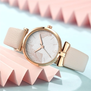 Detail of rose gold watch case with pink leather strap and bow decoration