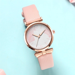 Detail of rose gold watch case with bow knot lugs and pink leaf patterned dial