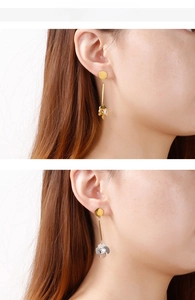 Detailansicht langer goldener Ohrhänger mit Zirkon-Blumenanhänger am Model