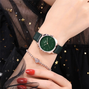 Detail of rose gold ladies' watch with deep green leather strap and matching heart bracelet