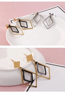 Detail view of geometric rhombus earrings in gold and silver finish on display