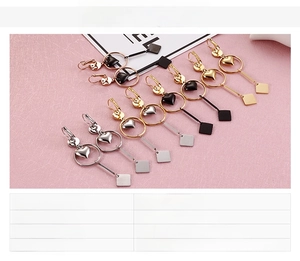 Macro detail of geometric heart earrings in polished gold, rose gold and silver finishes