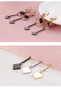 Detailed view of rose gold and silver geometric heart earrings on a textured background