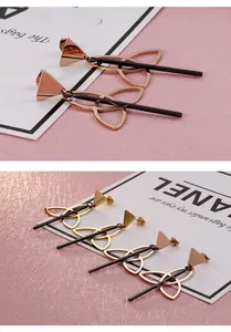 Macro shot of geometric triangle drop earrings in rose gold with black pendant bars