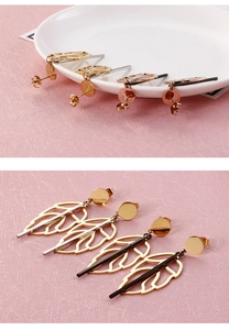 Detail showing gold leaf dangle earrings with black and silver bar accents on pink texture