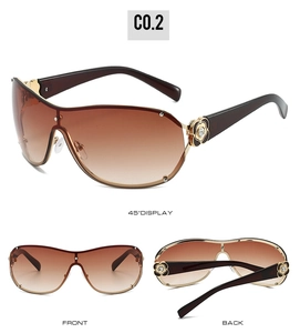 Detail view of large frame sunglasses with golden camellia floral rhinestone accent