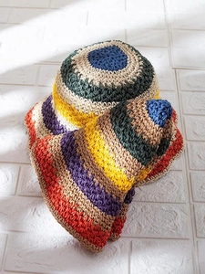 Detailed close-up of colorful crochet sun hat and scarf set with handmade texture