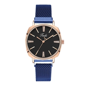 Détails d'une montre en or rose avec cadran noir et bracelet milanais bleu marine