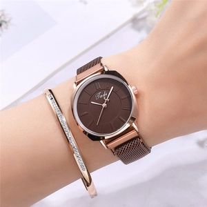 Détail du bracelet de montre milanais or rose et du jonc serti de cristaux