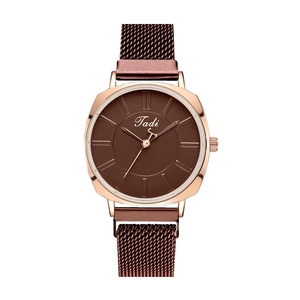 Détail du bracelet en maille or rose et du cadran marron café de la montre à quartz