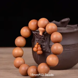 Detail of 18mm sandalwood Buddhist beads with classic knots over a purple clay teapot
