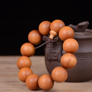 Macro detail of 20mm polished sandalwood beads with a decorative Chinese knot