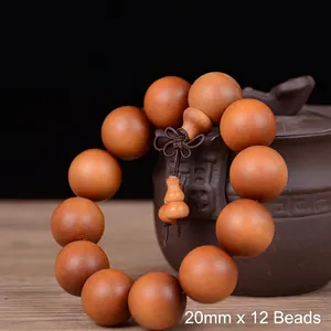 Detail of 20mm sandalwood beads with traditional knot on a rustic ceramic jar
