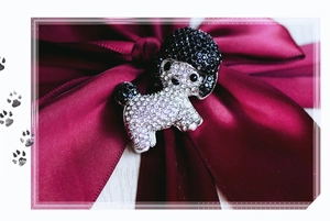 Macro shot of poodle brooch featuring sparkling white and black rhinestones on silver metal