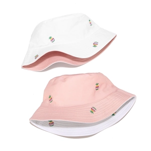 Detail of pineapple embroidery on reversible cotton bucket hats in pink and white