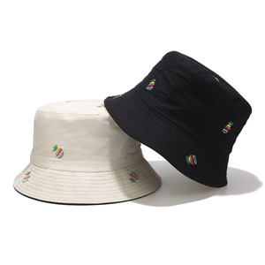 Detail of rainbow pineapple embroidery on black and beige cotton bucket hats