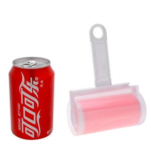 Washable pink lint roller with white handle for clothes cleaning shown next to a soda can