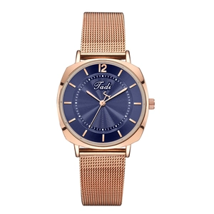 Détail d'une montre à quartz rose doré avec cadran bleu et texture ondulée