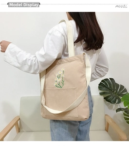 Detail of beige corduroy tote bag with daisy embroidery and adjustable shoulder strap