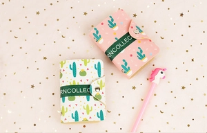 Detail of PU card holder with cactus patterns, snap fastener, and matching unicorn pen