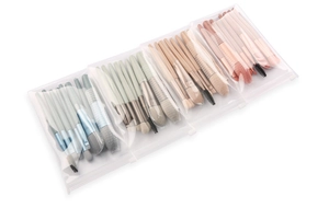 Detailed view of four colorful makeup brush sets in transparent zip bags on white background