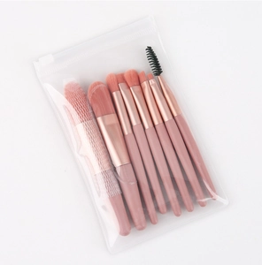 Detail of pink makeup brush set with rose gold ferrules in a clear travel zip pouch