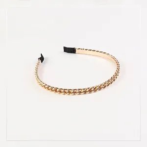 Close-up of golden chain headband with black fabric tips and high-polish finish