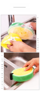 Detail of fruit-shaped sponge scrubbing a yellow ceramic bowl and stainless steel sink
