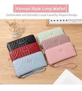Detailed top view of long zip wallets in multiple colors on a light wood background