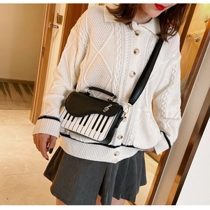 Chic piano keyboard crossbody bag shown on model for size and style perspective