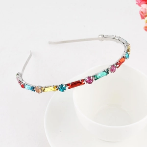 Detailed close-up of slim silver headband with colorful rhinestones and gemstones
