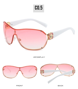 Detail view of pink gradient lenses and floral rhinestone accents on white sunglasses frames