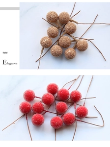 Detail of red frosted and gold textured artificial berries with stems for DIY decor
