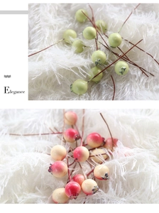 Detailed view of artificial berry stems in green and red yellow for home decor