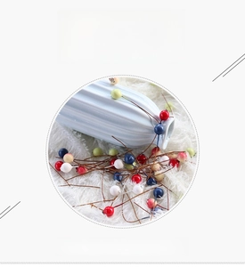 Close-up of colorful artificial blueberry berries on stems for home decoration and crafts
