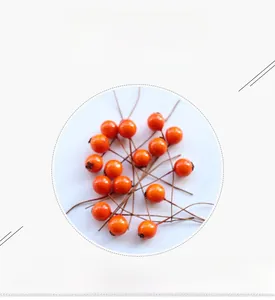 Detail of realistic orange foam berries with stems for pastoral DIY floral decoration