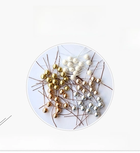 Close-up of 10mm metallic artificial berries in gold, silver, and copper for DIY crafts